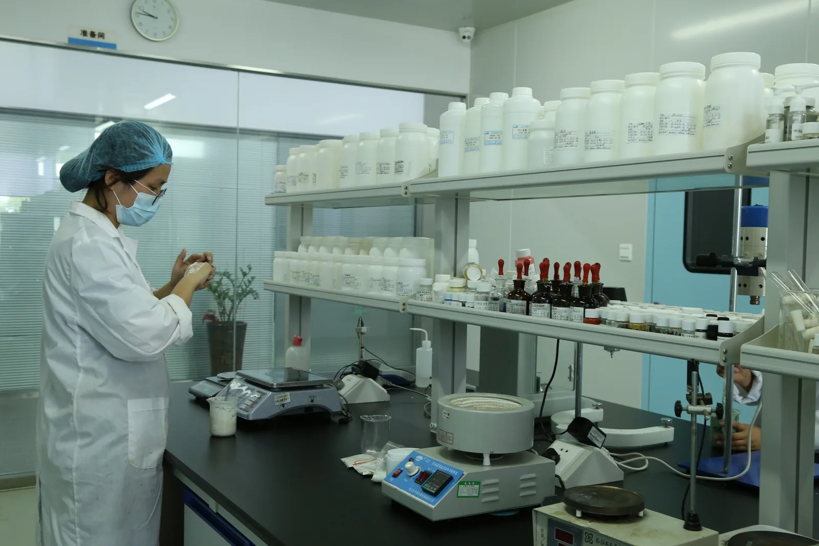 Technician preparing and weighing formulation samples at the R&D lab bench